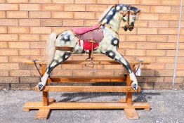 A small mid-century Collinson dapple grey rocking horse on trestle base, 87 cm (h),