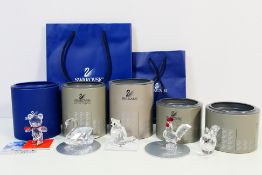 Five boxed Swarovski ornaments comprising a Kris Bear figure (ice skating), a swan, a cat,