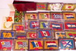 A binder of cigarette felts / blankets, all decorated with flags, approximately 15 cm x 21 cm,