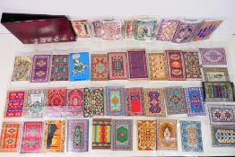 A binder containing in excess of forty Turkish miniature woven carpets, various designs,
