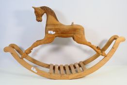 A carved wood model of a rocking horse, approximately 53 cm x 91 cm. [2].