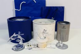Boxed Swarovski to include a dolphin ornament, studded swan with display plinth and a flower,