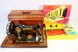 A vintage Jones Family CS sewing machine in wooden case and a Chad Valley Escalado game. [2].