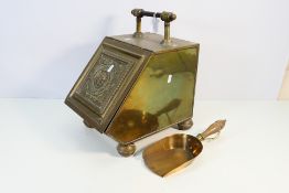 A brass Purdonium with embossed decorati