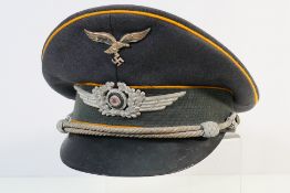 A cloth peaked cap bearing military insi