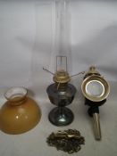 An oil lamp with yellow orange shade. A