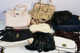 A mixed collection of various sized bags in various colours .