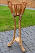 A plant stand with carved decoration of swan heads, 129 cm (h).
