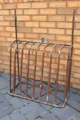 A wrought iron, wall mountable hay rack / horse feeder.