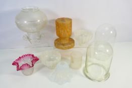 A collection of glass light shades and two glass domes.