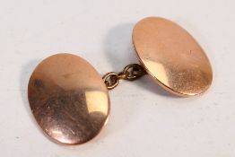 A rose metal cufflink, stamped 9 and marked 