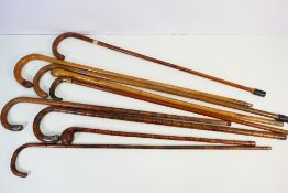 A collection of walking sticks including four with silver / white metal mounts (three bearing