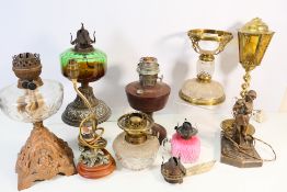 A collection of antique and later oil lamp bases and similar.