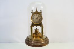 A Gustav Becker brass torsion clock housed under glass dome, 31 cm (h).