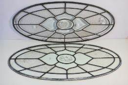 A pair of oval leaded glass windows, approximately 38 cm x 90 cm. [2].