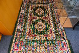 A Moroccan rug with two green medallions against a red ground, approximately 220 cm x 150 cm.