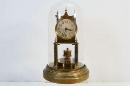 A Gustav Becker brass torsion clock housed under glass dome, 29 cm (h).