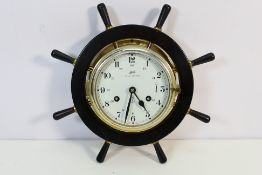 A Schatz Royal Mariner brass cased bulkhead clock housed in ship's wheel mount.