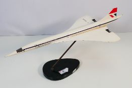 A painted wooden model of Concorde, mounted to wooden plinth, 34 cm (l).