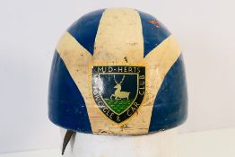 A vintage motorcycle racing helmet with Mid-Herts Motorcycle & Car Club decal.
