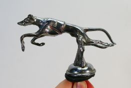 A vintage Desmo car mascot in the form of a racing greyhound, number 1, some remnants of paint,