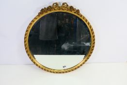 A gilt framed circular, bevelled edge wall mirror, approximately 55 cm (d).