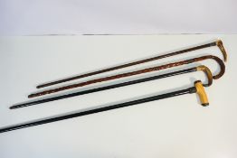 Four vintage walking sticks with silver