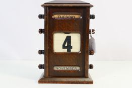 A vintage oak cased desktop perpetual calendar, approximately 20 cm x 13 cm x 8 cm.