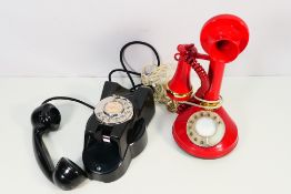 A vintage black dial telephone and a candlestick style telephone.