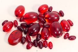 A quantity of cherry amber Bakelite beads, largest approximately 3 cm x 2 cm, smallest 0.7 cm x 0.
