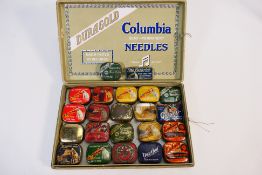 A vintage Columbia Duragold box containing a quantity of pictorial gramophone needle tins,