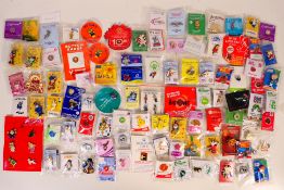 A collection of 90+ packaged pin badges, mostly charity together with some Noddy zip pulls.