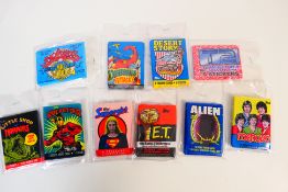 A collection of unopened trade card / bubble gum / sticker packs to include Menudo, Alien, E.