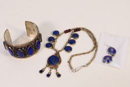 A lapis lazuli set white metal jewellery suite comprising bangle, necklace and earrings.