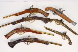 A collection of replica flintlock pistols.