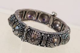 A Rajasthani style white metal hinged bangle, approximately 5.5 cm internal diameter.