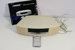A Bose Wave Music System, model AWRCC6 with remote, cable and paperwork.