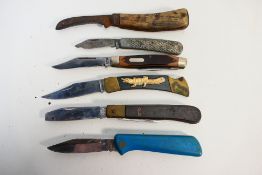 Knives - 6 medium-sized pocket knives of various styles and grips.