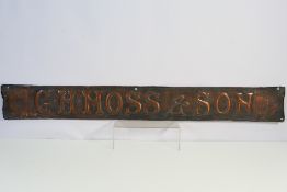 An antique embossed copper shop sign, G H Moss & Son, approximately 15 cm x 117 cm.