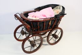 A vintage wooden dolls pram (approx 53 x 29 cm x 39 cm or 65 cm with hood up) contains a