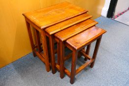 A nest of four tables with decorative brass inlay, largest approximately 54 cm x 53 cm x 33 cm.