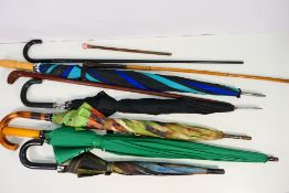 A quantity of walking sticks and umbrellas and one parasol handle with yellow metal mounted