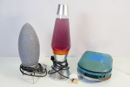 Two table lamps comprising a lava lamp and one in the form of a rocket,