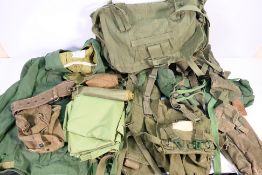 A mid-1970's military backpack containing various webbing, smock and similar.
