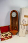 A boxed quartz wall clock and a vintage portable radio. [2].