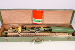 A cased Singer knitting machine, with instructions.