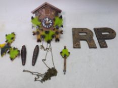 A vintage cuckoo clock with pendulum and two weights and two industrial cast iron letters, R and P.