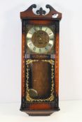 An Acctim 30 Day wall clock, with key and pendulum, approximately 77 cm.