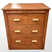 A 1920's ship's teak and pine chest of three drawers, with leather-inset pullout slide,