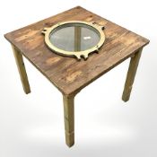 A home made pine square occasional table with inset brass porthole stamped 'Thompsons Pat.